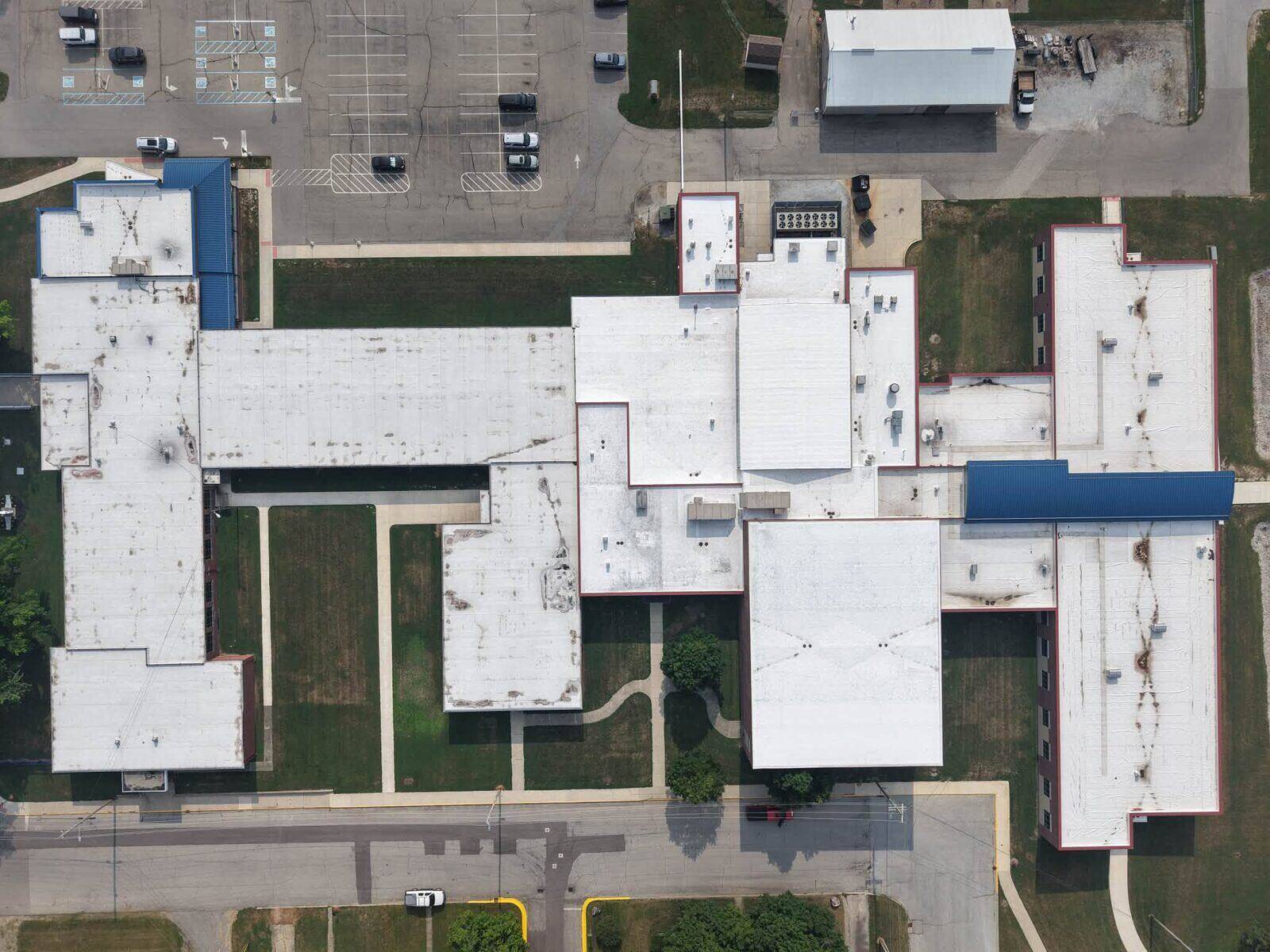 Aerial view of low-slope membrane roofing across a multi-building property.